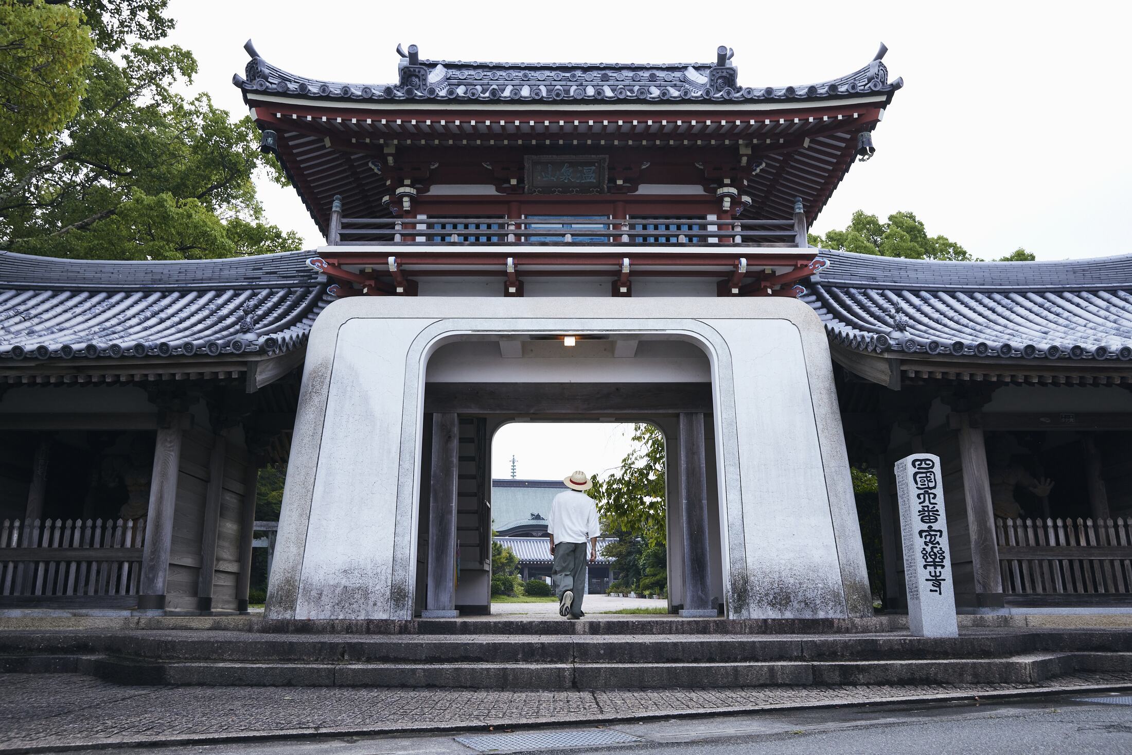 安楽寺の山門と、門をくぐる歩き遍路